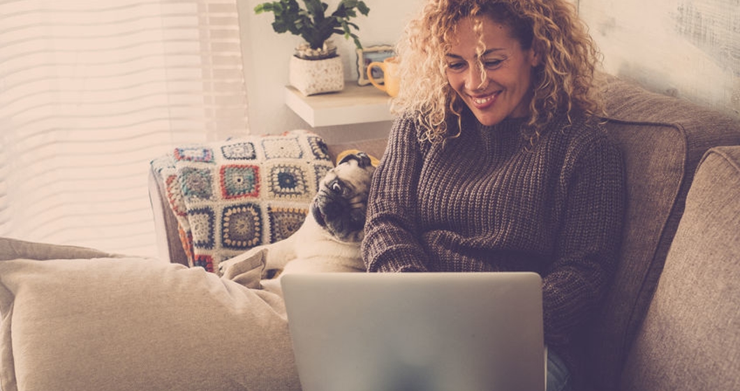 beautiful blonde curly woman working at home with a laptop inter