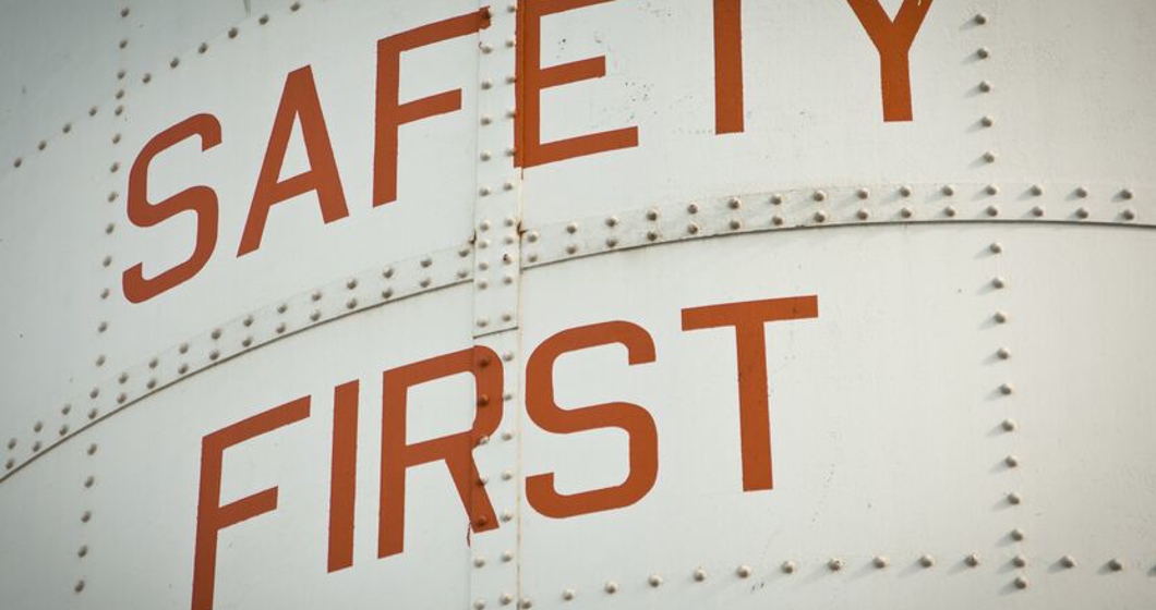 a metal work sign painted with the words safety first.
