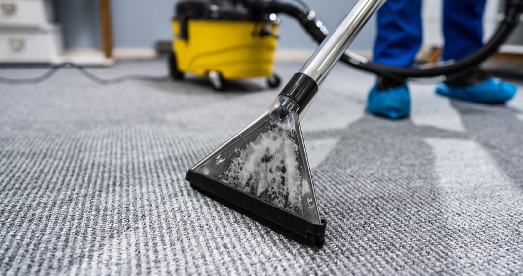 Person Cleaning Carpet With Vacuum Cleaner