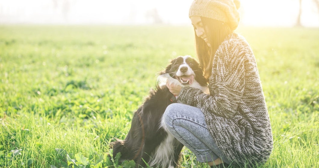 Young woman playing and enjoying the time with her dog