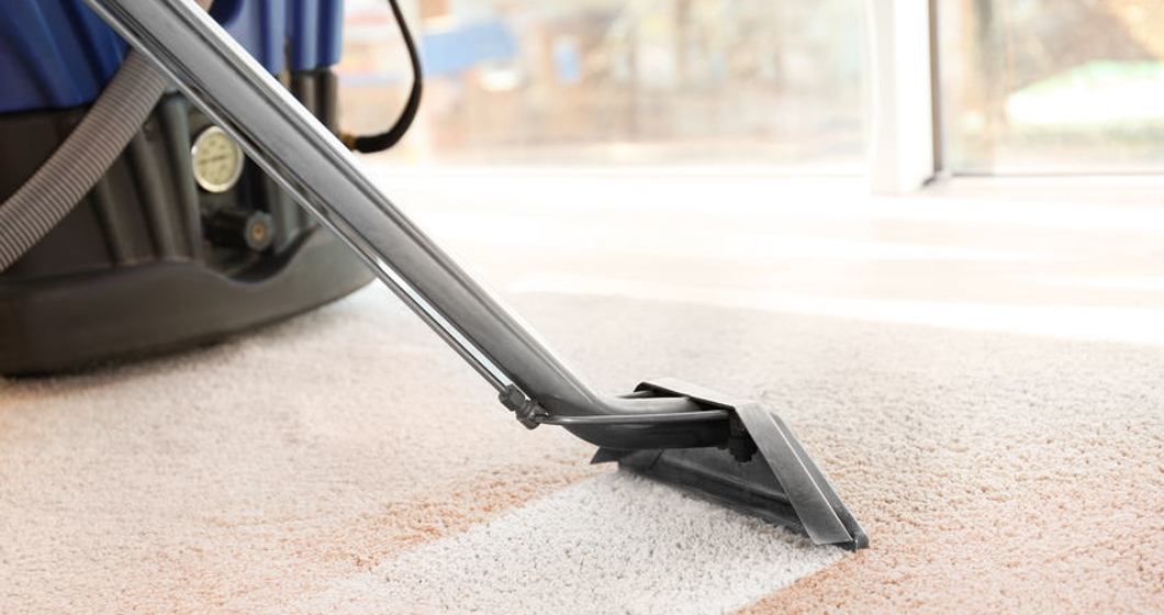 Cleaning service concept. Steam vapor cleaner removing dirt from carpet in flat, closeup