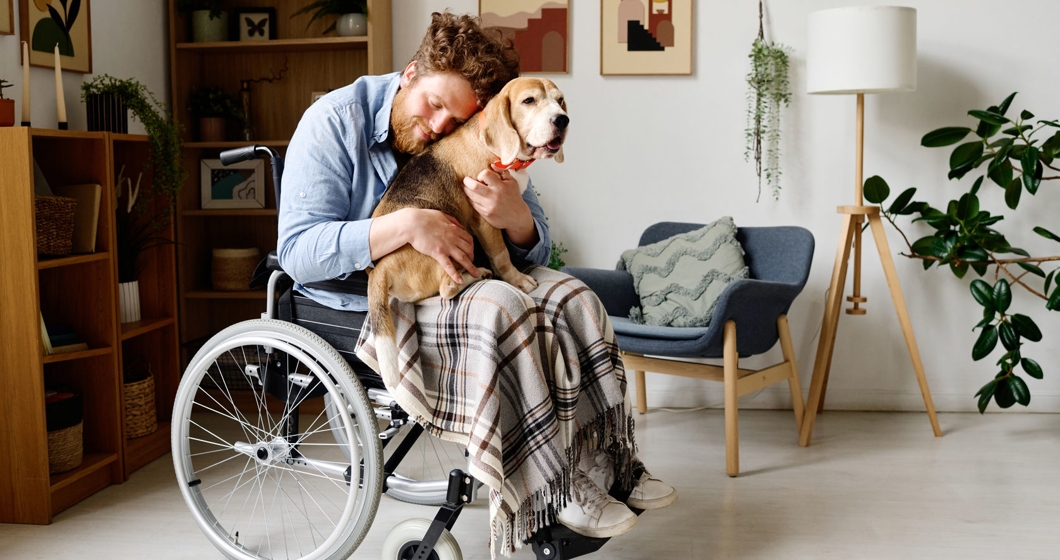Man with disability comforting himself with dog