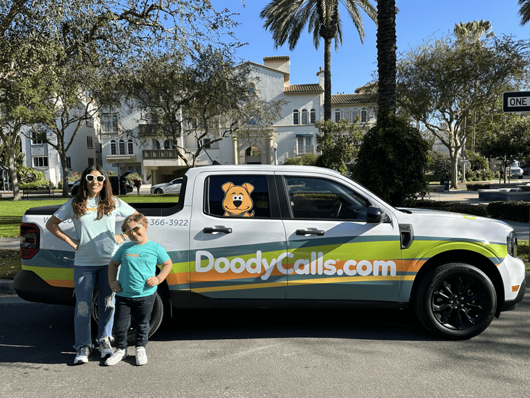 DoodyCalls owner and son in front of DoodyCalls truck
