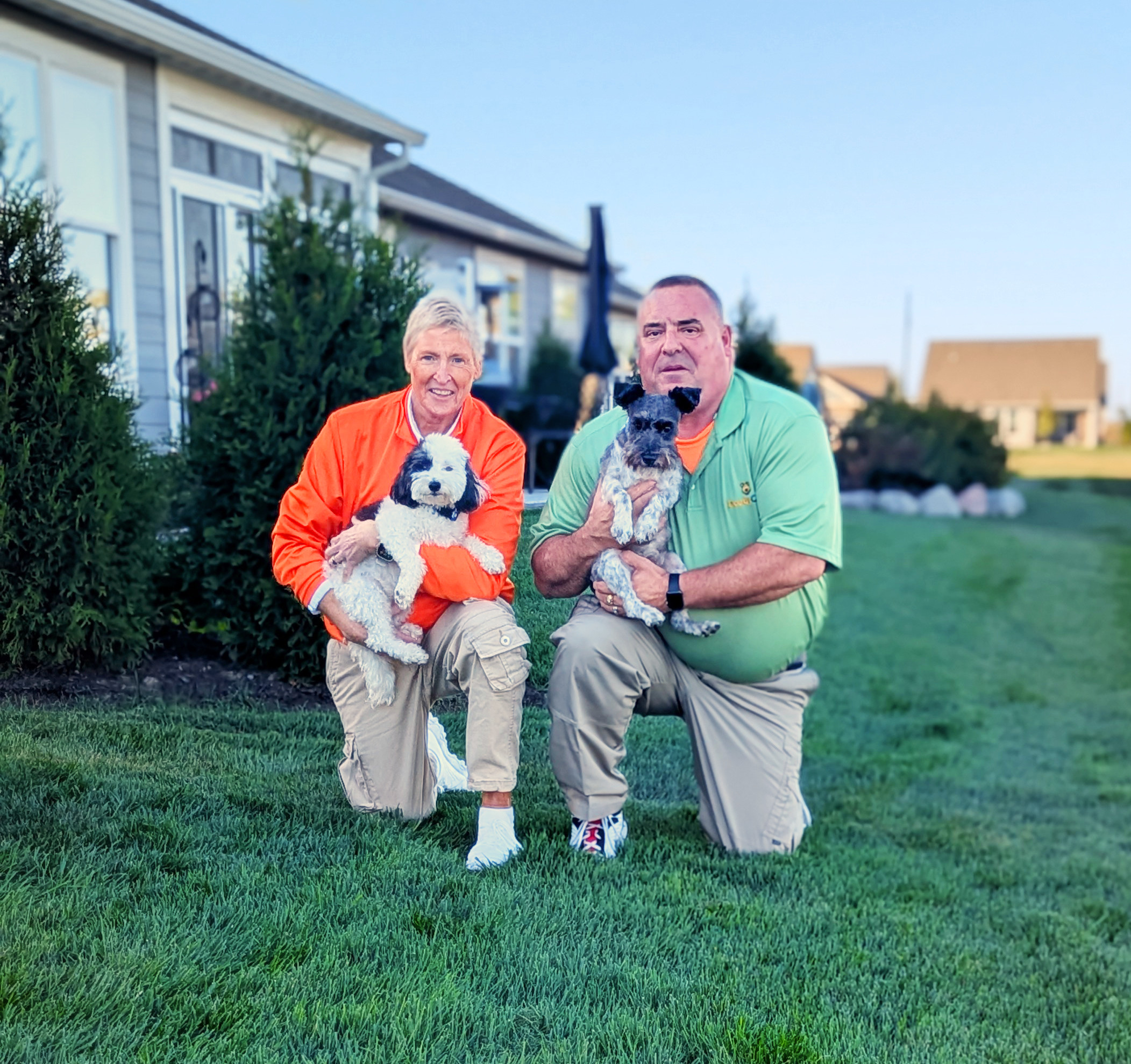 a man and woman each holding a dog